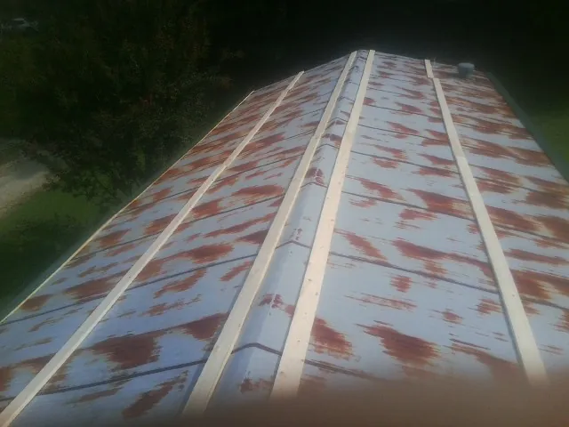 Rusted metal roof panels with new wood purlins before replacement — Storm Damage Roof Repair in Grandy by Roofing Brothers